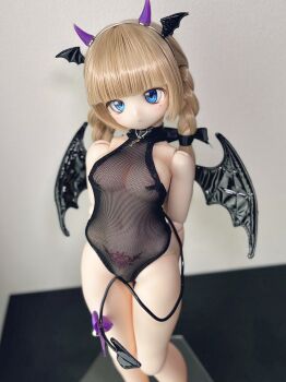 1girl absurdres arms_behind_back blue_eyes figure fishnet_leotard fishnets head_wings highres horns leotard photo_(medium) pubic_tattoo see-through_clothes see-through_leotard tail tattoo wings