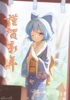 1girl ;) absurdres ahoge alternate_costume blue_bow blue_eyes blue_hair blue_kimono blurry blurry_background blurry_foreground blush bow cirno commentary_request depth_of_field detached_wings fairy fur-trimmed_kimono fur_trim furisode hair_bow happy_new_year highres ice ice_wings japanese_clothes kimono lbcirno9 looking_at_viewer multiple_wings new_year obi one_eye_closed own_hands_together palms_together rope sash shimenawa short_hair shrine smile solo touhou translation_request twitter_username wings