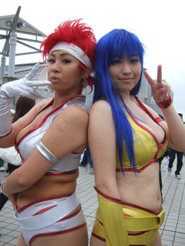 2girls belt blue_eyes breasts cleavage cosplay_photo crop_top dark_skin dirty_pair headband kei_(dirty_pair) kei_(dirty_pair)_(cosplay) long_hair multiple_girls navel outdoors photo_(medium) plump real_life red_hair short_hair short_shorts shorts v yuri_(dirty_pair) yuri_(dirty_pair)_(cosplay)