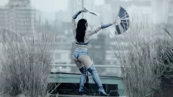 1girl ass bare_shoulders black_hair blue_thighhighs boots cosplay dual_wielding female_focus holding holding_weapon kitana kitana_(cosplay) long_hair mortal_kombat_(series) mortal_kombat_9 rachelle_glover solo thigh_boots thighhighs tiara vambraces weapon
