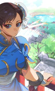 1girl blue_dress bracelet breasts brown_eyes brown_hair bun_cover capcom china_dress chinese_clothes chun-li closed_mouth dress hair_bun hand_on_railing highres jewelry outdoors short_sleeves sideways_glance sitting solo spiked_bracelet spikes street_fighter yumi_xsh