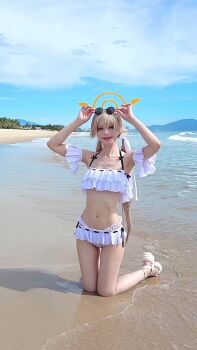 1girl absurdres animated armpits beach bikini blue_archive blue_sky cloud commentary_request cosplay_photo day frilled_bikini frills halo hifumi_(blue_archive) highres ighs kneeling navel ocean outdoors photo_(medium) real_life sandals sitting sky sound splashing stomach sunglasses swimsuit video white_bikini white_sandals yamo8cos