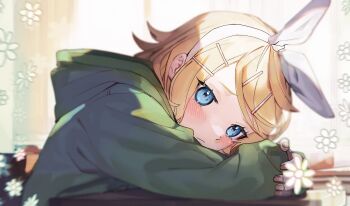 1girl :/ blurry commentary_request desk green_hood hair_ornament hairband hairpin head_down highres kagamine_rin looking_at_viewer melancholic_(vocaloid) solo soyaka upper_body vocaloid white_hairband