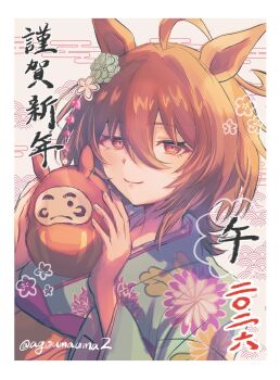 1girl agnes_tachyon_(umamusume) agoumauma2 ahoge animal_ears brown_hair closed_mouth commentary_request daruma_doll doll floral_print floral_print_kimono hair_between_eyes hair_ornament highres holding holding_doll horse_ears horse_girl japanese_clothes kimono long_sleeves medium_hair print_kimono red_eyes smile solo umamusume
