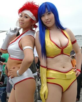 2girls belt blue_eyes breasts cleavage cosplay_photo crop_top dark_skin dirty_pair hand_on_own_hip headband kei_(dirty_pair) kei_(dirty_pair)_(cosplay) long_hair multiple_girls navel outdoors photo_(medium) plump real_life red_hair short_hair short_shorts shorts yuri_(dirty_pair) yuri_(dirty_pair)_(cosplay)