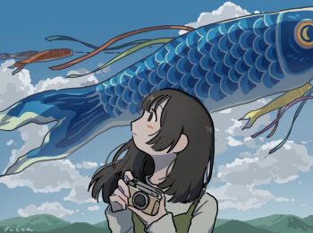 1girl artist_name blue_sky blush brown_hair camera carp cloud cloudy_sky commentary dress dress_over_shirt fucca green_dress holding holding_camera kite koi koinobori long_hair long_sleeves looking_to_the_side looking_up mountainous_horizon original sidelocks sky solo symbol-only_commentary windsock