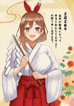 1girl 2026 atelier_(series) atelier_ryza braid breasts brown_eyes brown_hair commentary_request cowboy_shot crown_braid gohei hakama hakama_skirt highres holding janqoo89 japanese_clothes kosode large_breasts looking_at_viewer miko oonusa open_mouth red_hakama reisalin_stout short_hair skirt smile solo straight-on teeth translation_request upper_teeth_only yellow_background