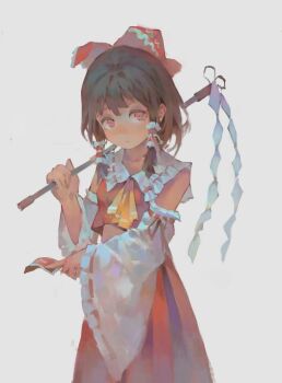 1girl ascot between_fingers bow brown_hair commentary detached_sleeves frilled_bow frilled_hair_tubes frills gohei grey_background hair_bow hair_tubes hakurei_reimu highres holding holding_gohei long_hair looking_at_viewer ofuda ofuda_between_fingers red_bow red_eyes red_skirt ribbon-trimmed_sleeves ribbon_trim simple_background skirt skirt_set solo ta&#039;er touhou yellow_ascot