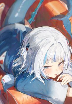 1girl :p blue_eyes blue_hair blue_hoodie blurry blush couch fins fish_tail gawr_gura grey_hair hashtag-only_commentary highres hololive hololive_english hood hoodie kouchanthree looking_at_viewer lying on_couch on_stomach shark_girl shark_tail solo tail tongue tongue_out two_side_up