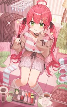 1girl ahoge alternate_costume atatatatame01 black_nails black_ribbon breasts chopsticks commentary_request green_eyes hair_ribbon highres holding holding_chopsticks hololive large_breasts long_hair looking_at_viewer nail_polish pink_socks pink_sweater ribbon sakura_miko smile socks solo sweater twintails very_long_hair virtual_youtuber