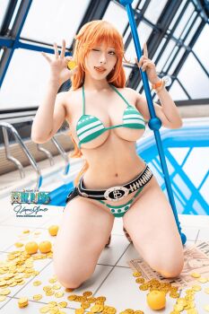 1girl absurdres artist_name bikini breasts clima-tact copyright_name cosplay cosplay_photo female_focus food fruit green_bikini hane_ame hat highres large_breasts nami_(one_piece) nami_(one_piece)_(cosplay) nami_(one_piece)_(return_to_sabaody) one_piece orange_(fruit) orange_hair patreon_username photo_(medium) poolside real_life rei_no_pool solo straw_hat swimsuit wanted_poster watermark web_address