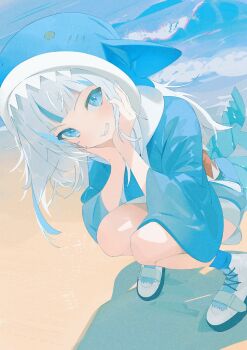 1girl animal_hood beach blue_eyes blue_hoodie blue_nails blue_socks blue_streaks blunt_bangs blush commentary_request fins fish_tail gawr_gura gawr_gura_(1st_costume) highres hololive hololive_english hood hood_up hoodie koyo2023 looking_at_viewer medium_hair multicolored_hair nail_polish partial_commentary sand shark_girl shark_hood shark_tail shoes sidelocks smile sneakers socks solo streaked_hair tail virtual_youtuber water white_hair white_shoes